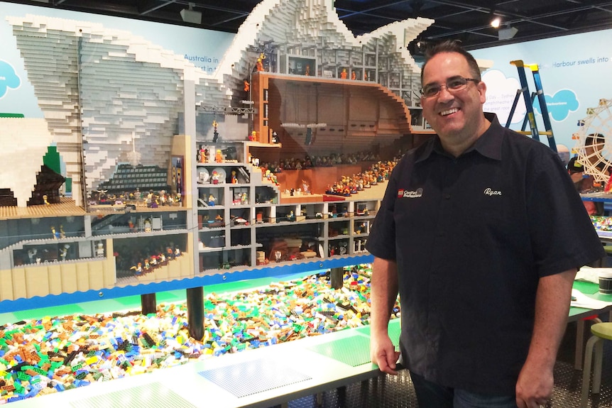 Ryan McNaught stands in front of his Lego Sydney Opera House at the Museum of Sydney