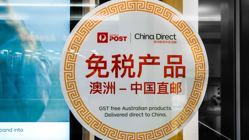 A sign on the outside of an Australian Post daigou store with the words "GST free Australian products. Delivered direct to China