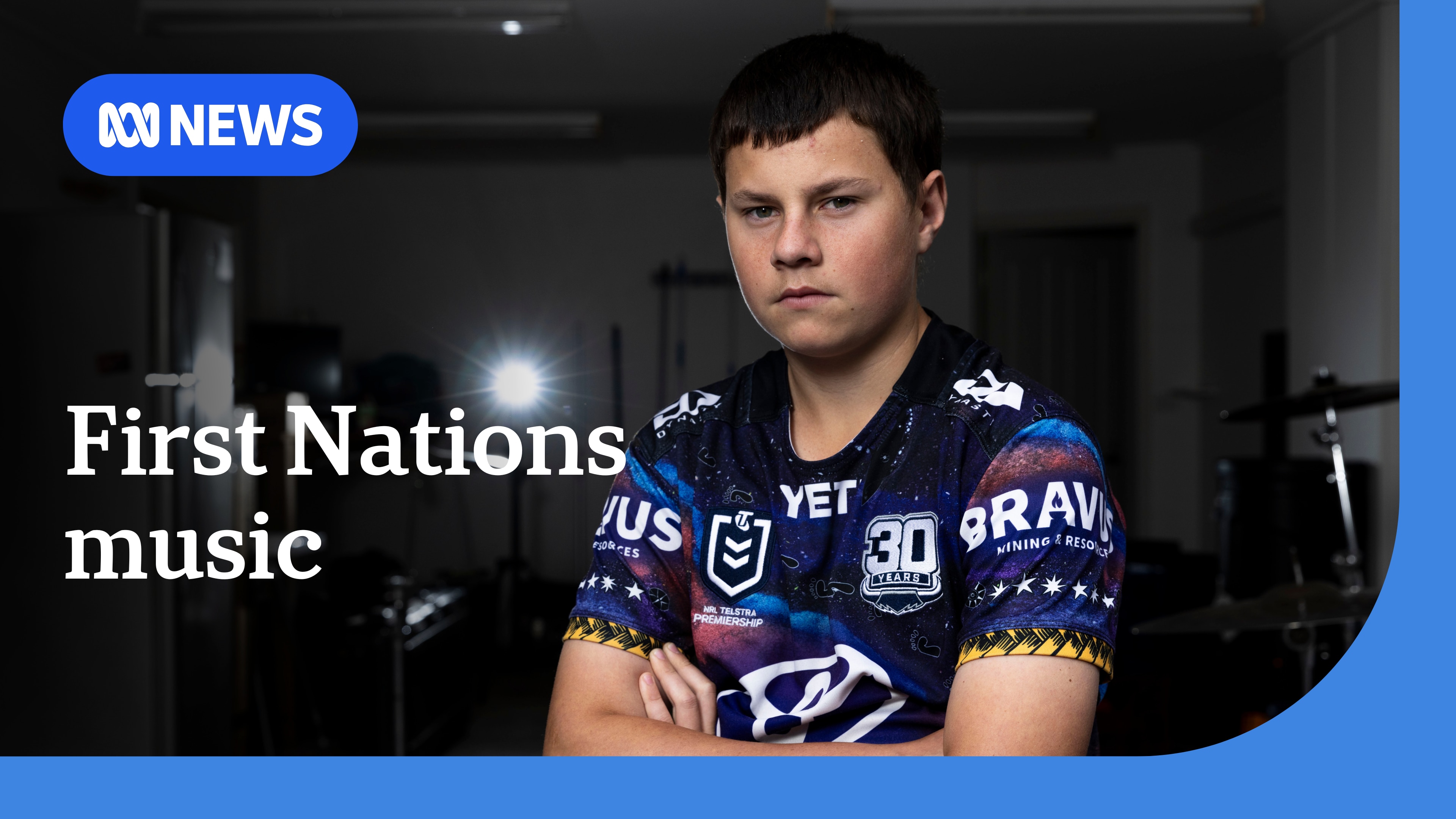 A boy sitting in a room with his arms crossed.