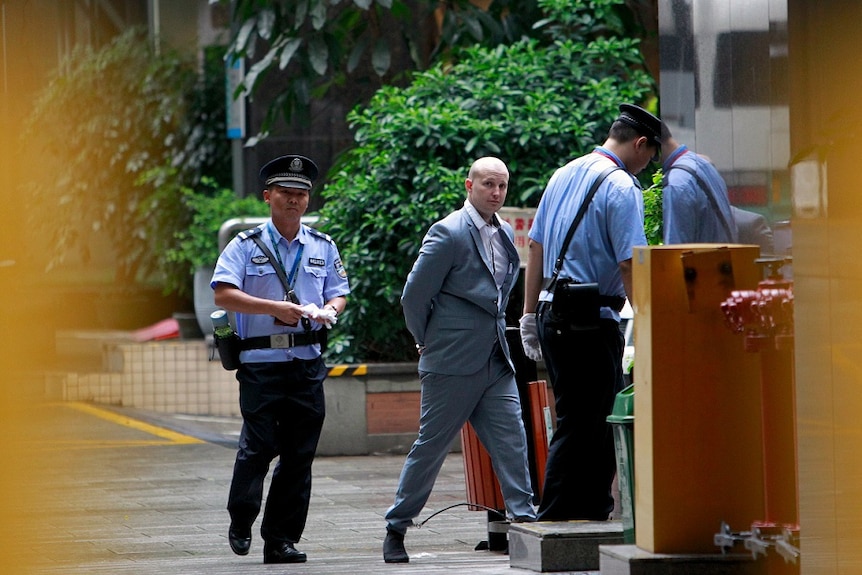 Police escort Peter Gardner as he enters court in Guangzhou, Guangdong province, China, May 7, 2015.