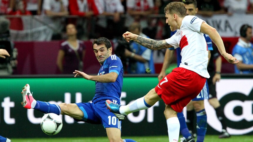 Eugen Polanski shoots at goal as Giorgos Karagounis attempts to block him during Euro 2012.