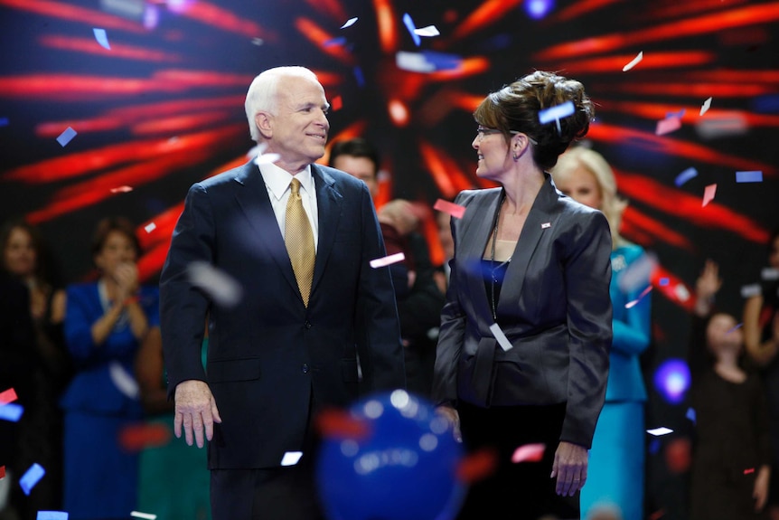 John McCain and Sarah Palin looking at each other as confetti falls around them