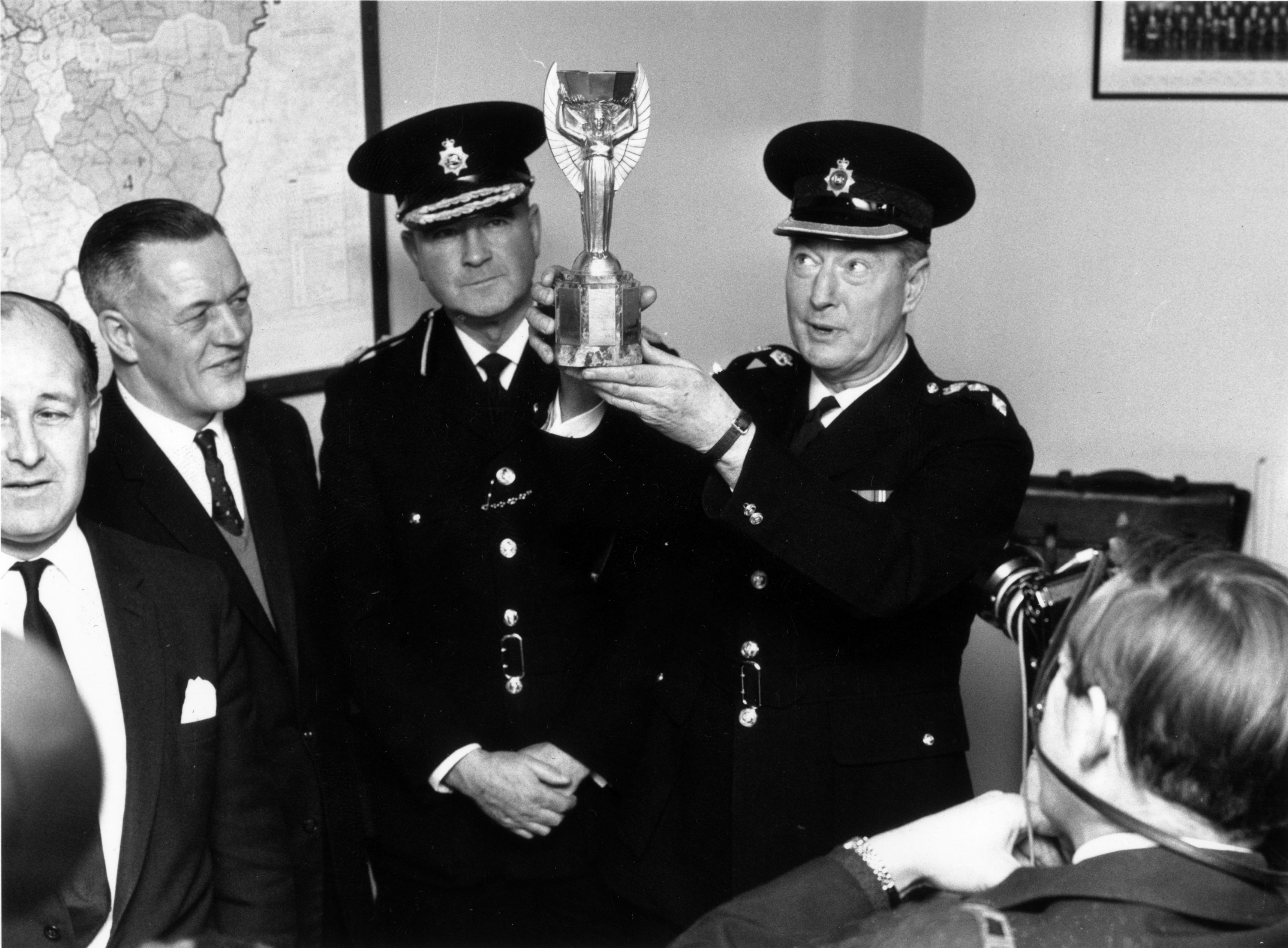 A police officer holds aloft a trophy