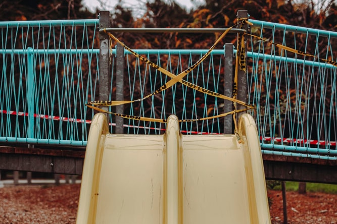 A yellow slide taped off with yellow caution tape.