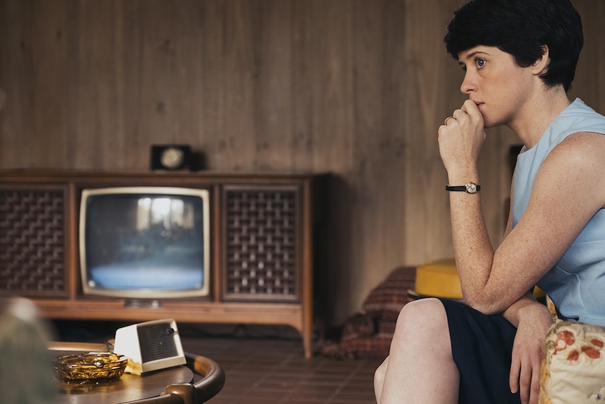 Still of Claire Foy sitting alone in a living room in 2018 film First Man.