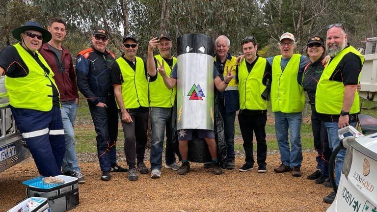 Ten people in high-vis yellow vests and a man dressed as a giant battery