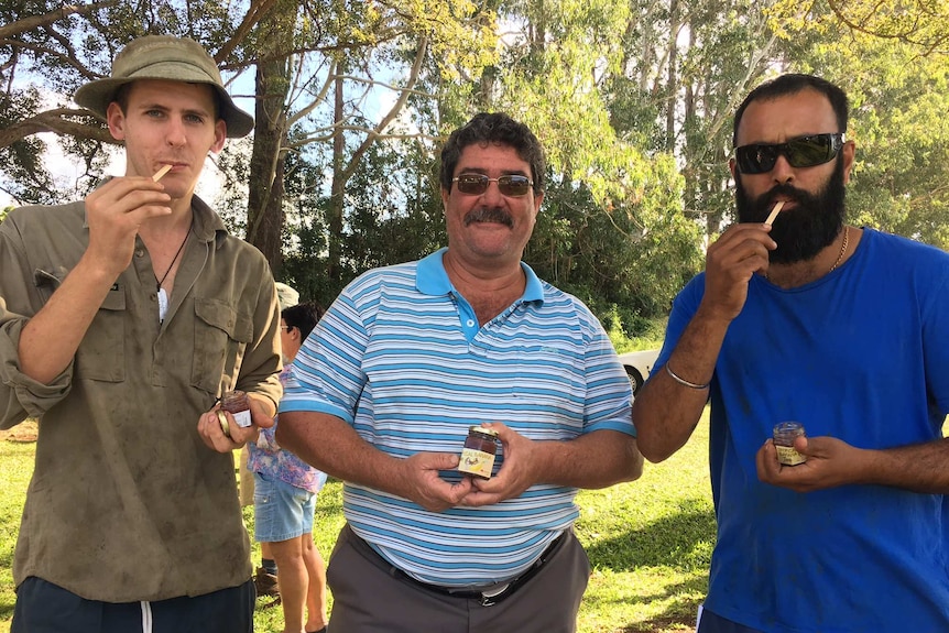 Two banana growers taste banana jam next to creator Alain Legrand.