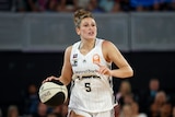 A woman dribbles during a basketball game