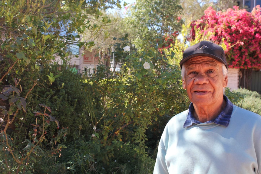 Central Arrernte man Tony Liddle standing in front of a garden