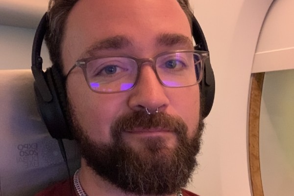 A man sitting on a plane with headphones on.