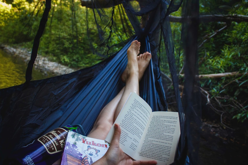 Woman lying in hammock reading a book for a story about being single after divorce.