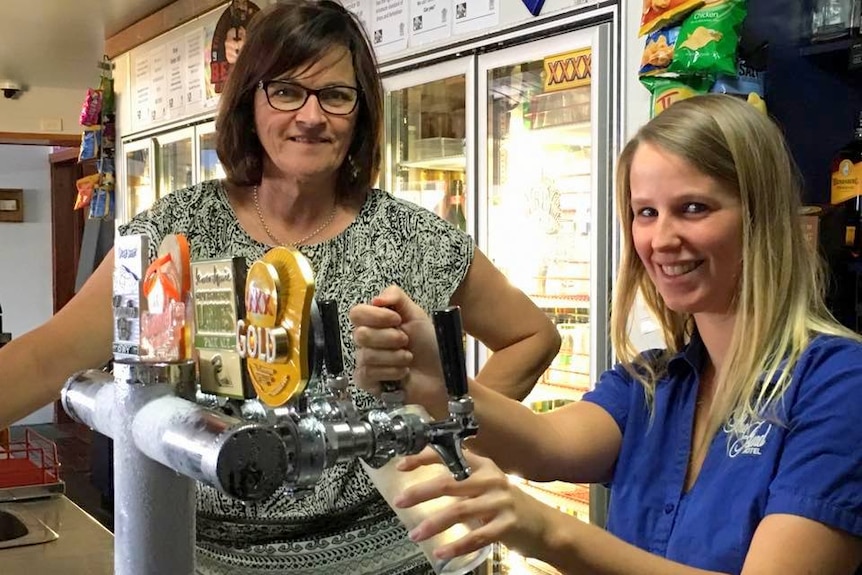 Clermont publican Leanne Appleton helps a staff member pull a beer.