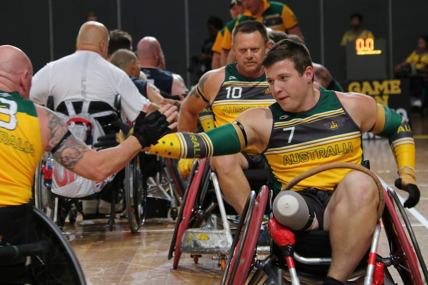 A man in a chair with his arm extended.