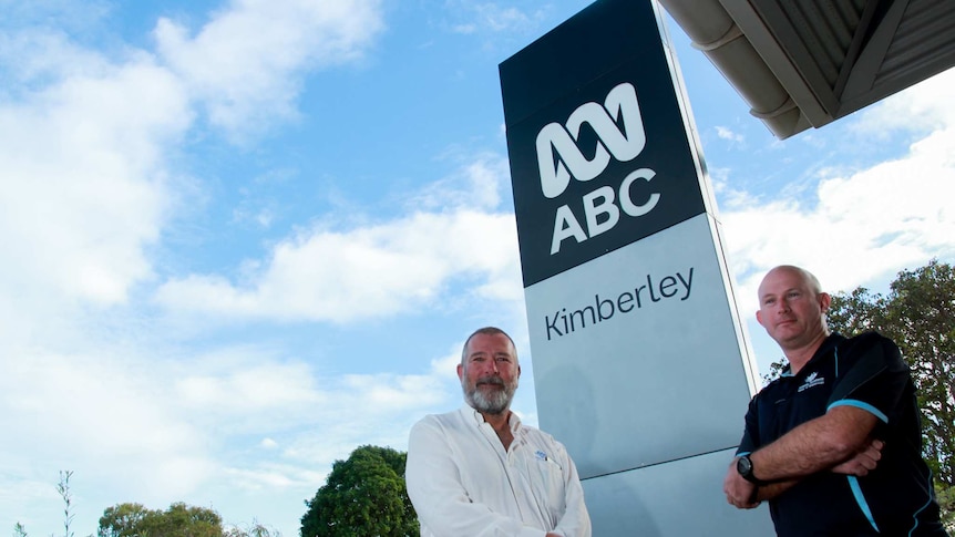 Two men stand outside the ABC Kimberley sign