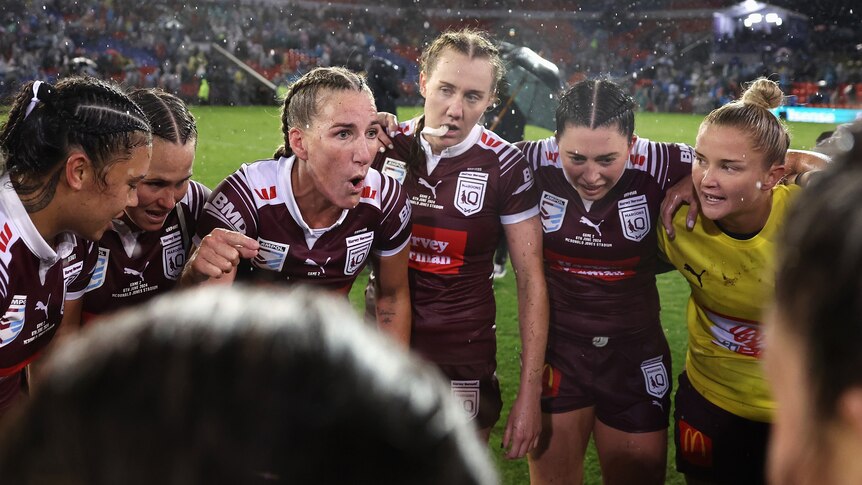 A woman addresses her team during a rugby league match