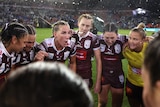 A woman addresses her team during a rugby league match