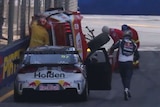 Holden driver Shane van Gisbergen gets out of his car and runs towards the upturned Ford of Scott McLaughlin.