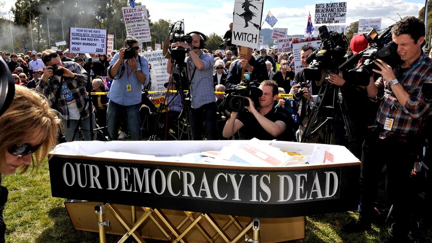 A coffin at an anti-carbon tax rally outside Parliament House, Canberra, sits in front of protesters