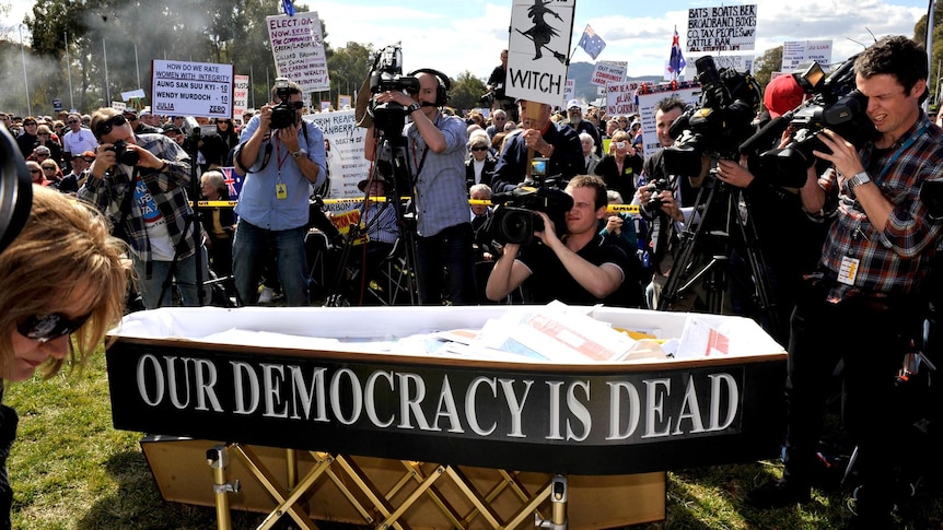 A coffin at an anti-carbon tax rally outside Parliament House, Canberra, sits in front of protesters