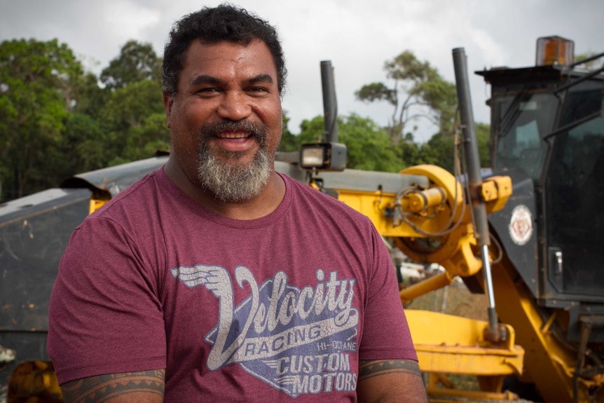 Lockhart River councillor Paul Piva stands in front of the machinery used to redevelop roads in the area.