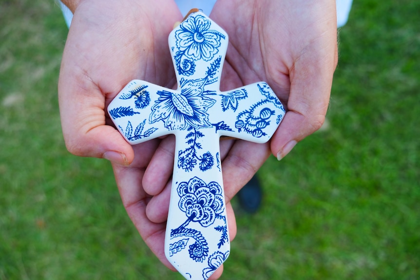 Woman's hands holding a Christian cross