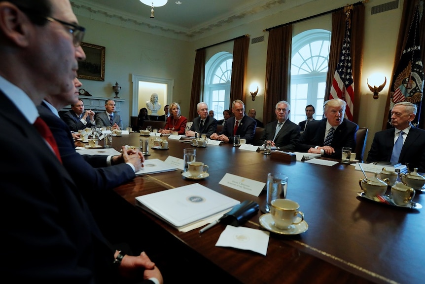 A Cabinet meeting table with President Trump in the middle