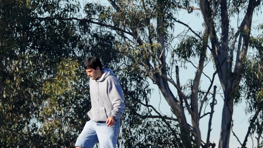 Asylum seekers sit on the roof of Villawood detention centre