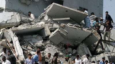 Pakistani volunteers work at a collapsed building following an earthquake in Islamabad