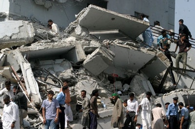 Pakistani volunteers work at a collapsed building following an earthquake in Islamabad
