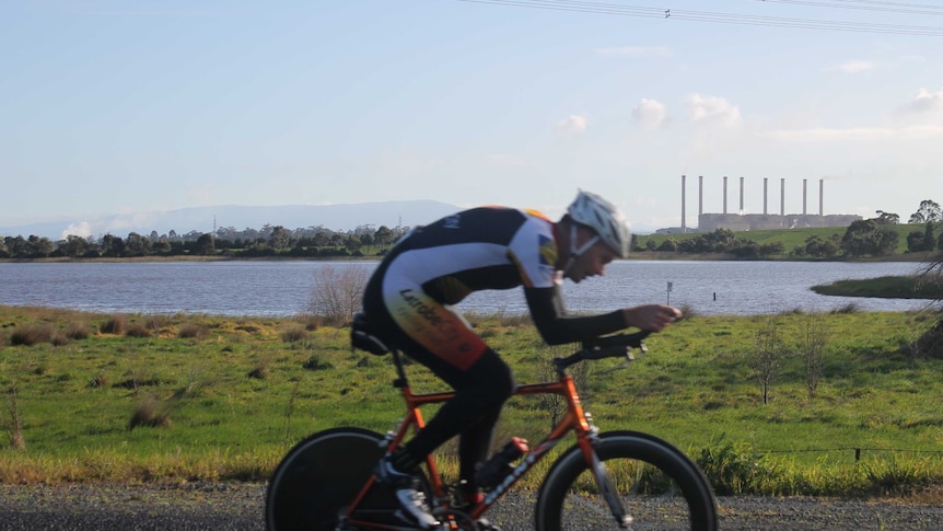 Cyclists riding in front of Hazelwood power station and the Hazelwood pondage.