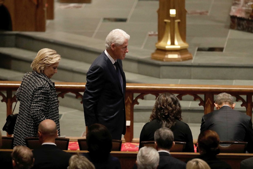 Hillary and Bill Clinton arrive at Barbara Bush's funeral, with Michelle and Barack Obama seated next to them.