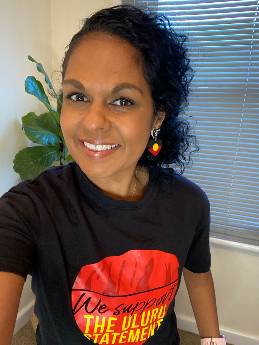 Teela Reid wears a black t-shirt that reads 'We Support The Uluru Statement'