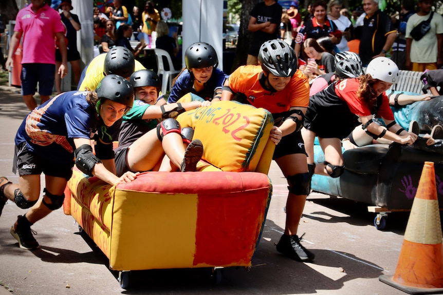 kids push a girl on a decorated couch