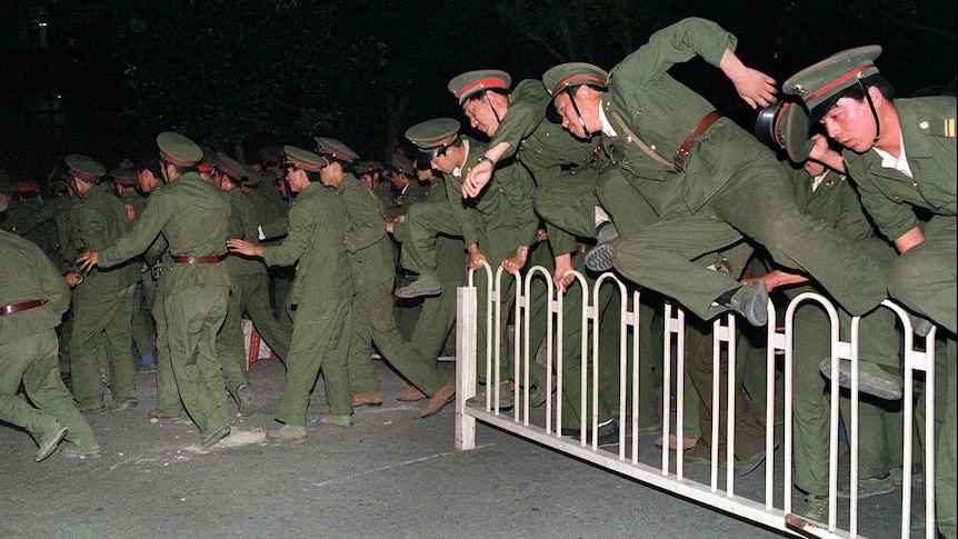 People Liberation Army (PLA) soldiers leap over a barrier on Tiananmen Square.