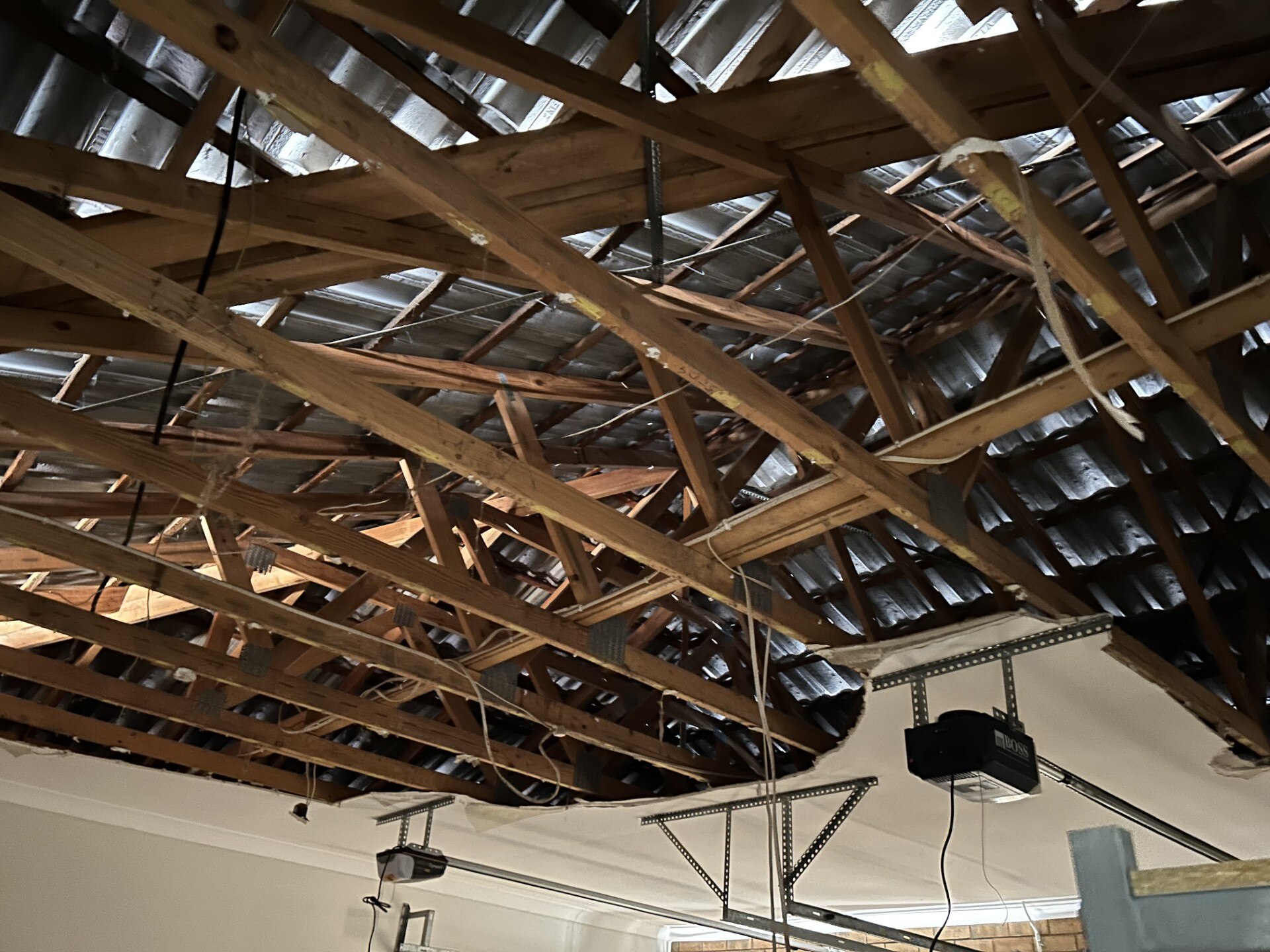 Vigas de suporte de madeira expostas sob o teto de uma sala.