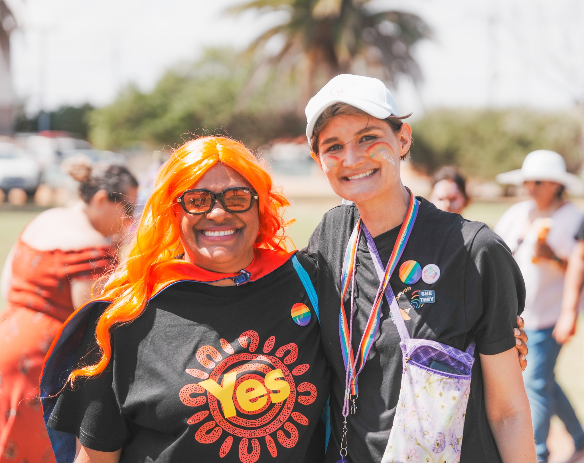 Two people stand smiling together. One wears a Yes shirt and long, bright orange hair.