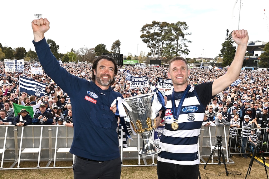 Geelong head coach Chris Scott and captain Joel Selwood of Geelong present the Premiership Cup to supporters.