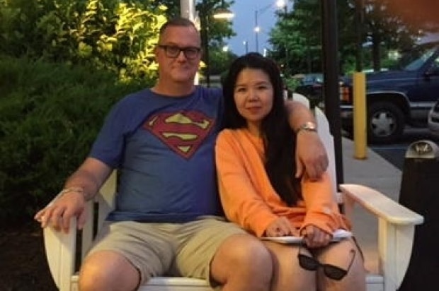 Chinese Crown employee Jenny Jiang with husband Jeff Sikkema sitting in a large chair together.
