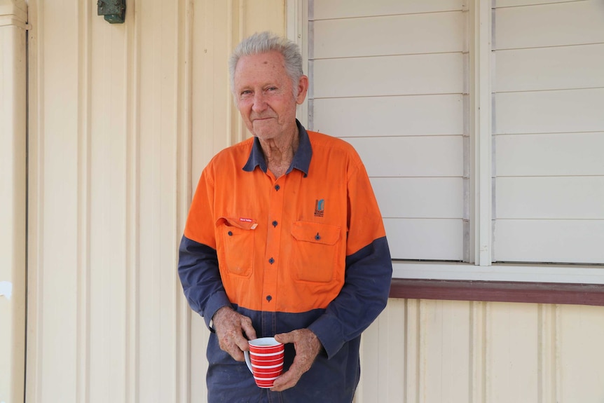 A man dressed in hi-vis holding a cup of tea