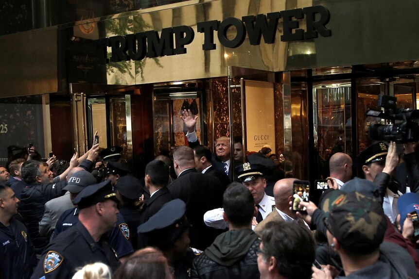 Donald Trump waves to supporters outside the front door of Trump Tower