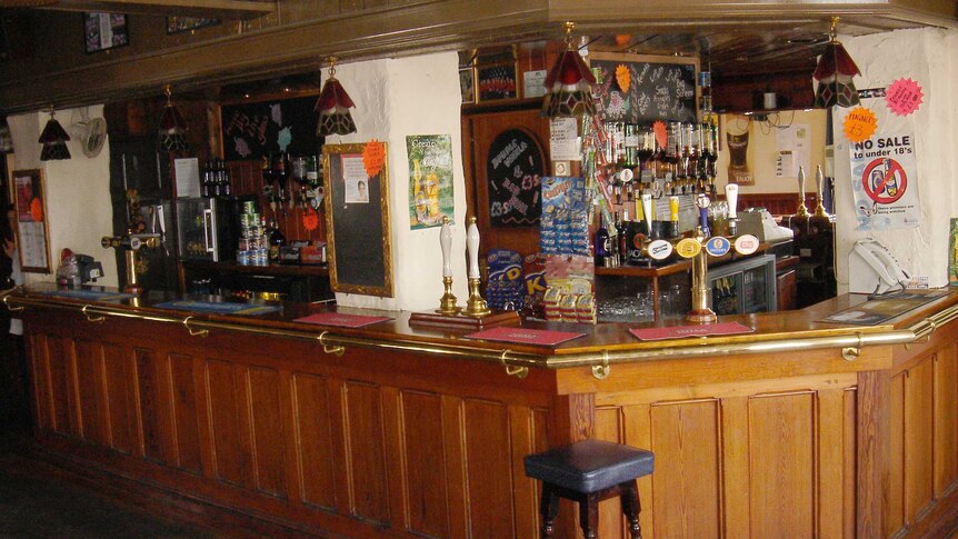 A wood-panelled bar inside a traditional English pub.