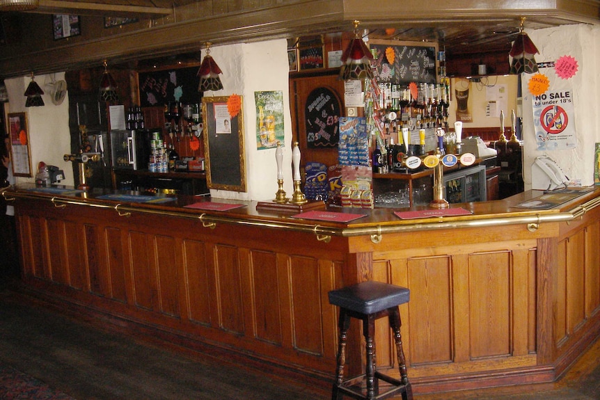 A wood-panelled bar inside a traditional English pub.