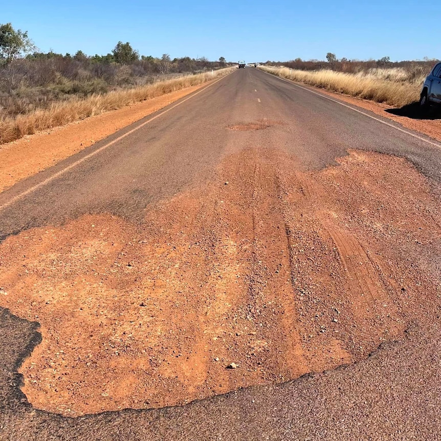a big pothole on a bitumen road.