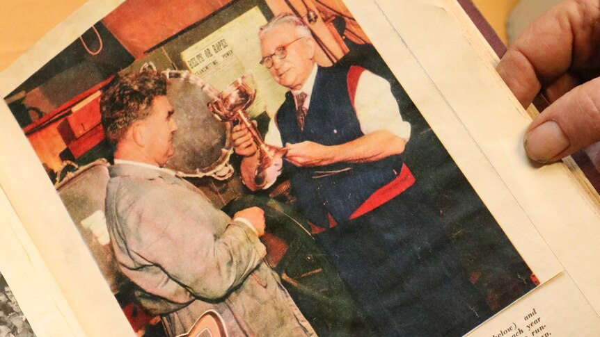 James Steeth passing the Melbourne Cup baton onto his son Maurice as the making gets handed down from a newspaper clipping.