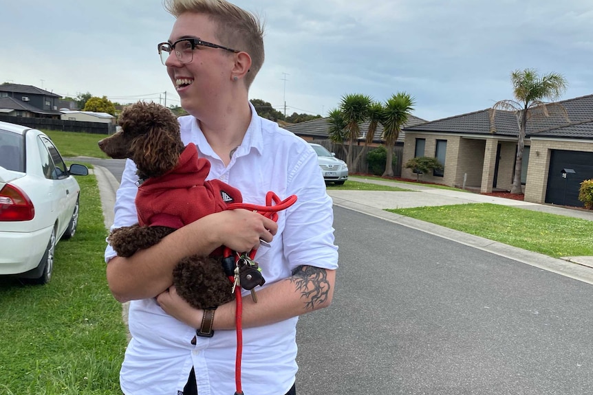 Ash standing in front of house with pet dog