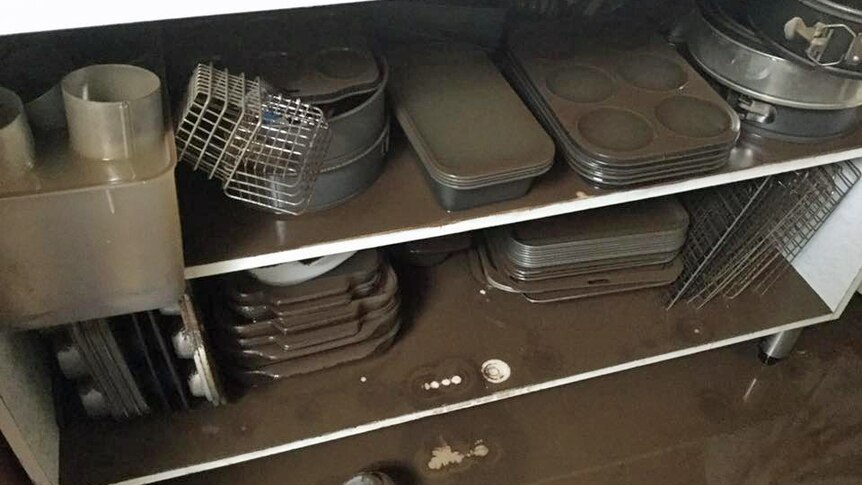 Kitchen cooking utensils covered in flood water and mud