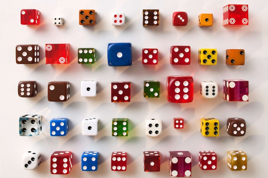 An assortment of dice in different shapes and colours, laid in a grid pattern.