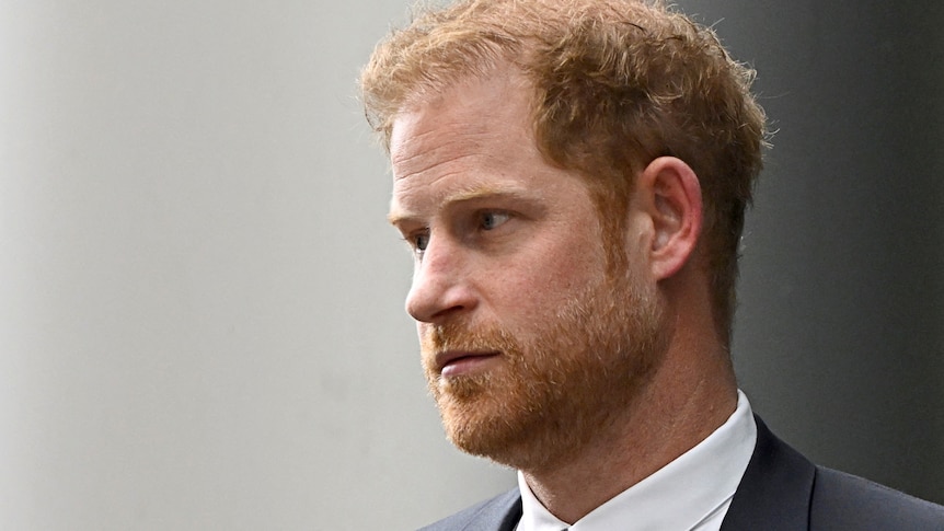A close-up of Prince Harry who wears a suit and has a serious expression.