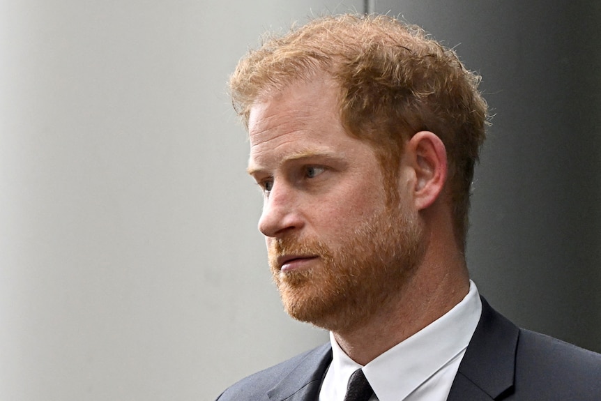 A close-up of Prince Harry who wears a suit and has a serious expression.