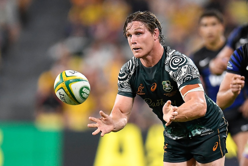 Michael Hooper passes the ball with Argentina players in hot pursuit behind him